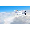 Young businessman with megaphone flying high in sky