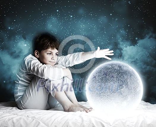 Cute boy sitting in bed with moon Cute boy sitting in bed with moon