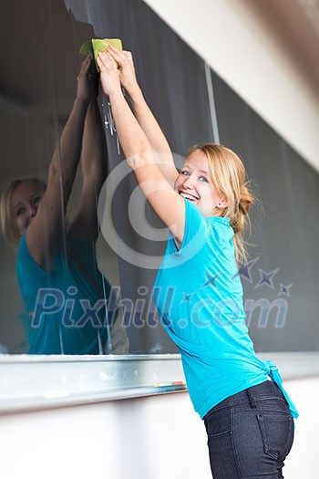 Pretty young college student or teacher washing the chalkboard/blackboa rd during class (shallow DOF; color toned image)