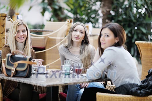 very cute smiling women drinking a coffee sitting inside in cafe restaurant