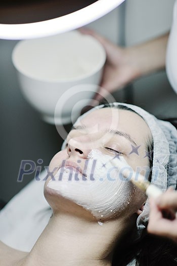 Young beautiful woman receiving cosmetic facial mask in spa beauty salon and relax Young beautiful woman receiving cosmetic facial mask in spa beauty salon and relax