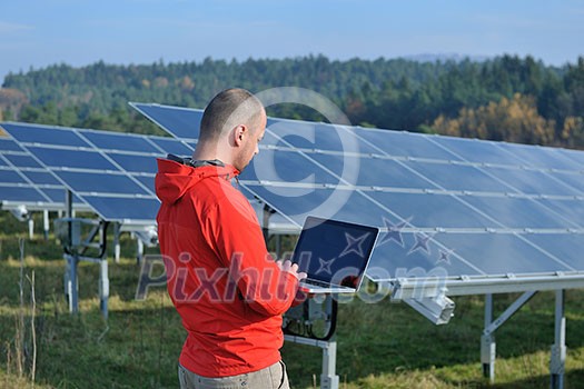 business man  engineer using laptop at solar panels plant eco energy field  in background