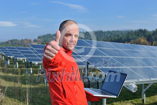 business man  engineer using laptop at solar panels plant eco energy field  in background