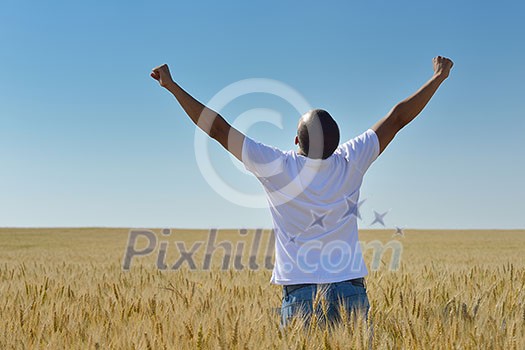 young man in wheat field representing success agriculture and freedom concept