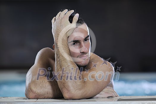 young healthy good looking macho man model athlete at hotel indoor pool