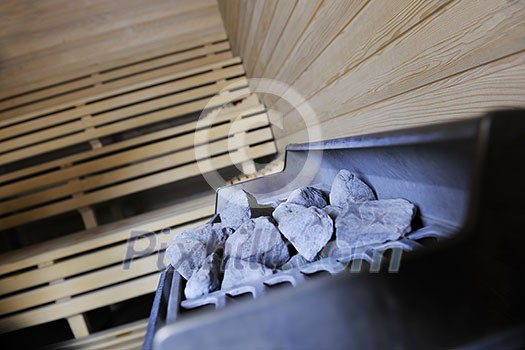 wooden luxury sauna indoor with hot stones and falling splashing water