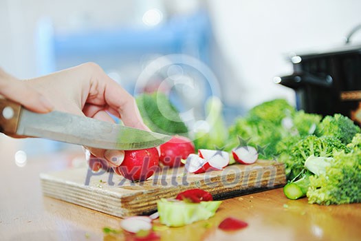 woman preparing healthy food salad with green and red vegetable and knife