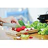 woman preparing healthy food salad with green and red vegetable and knife