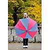 happy girl with umbrella outdoor in park on autumn season rain day