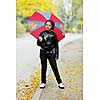 happy girl with umbrella outdoor in park on autumn season rain day