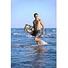 Portrait of a strong young  surf  man at beach on sunset in a contemplative mood with a surfboard