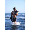 Portrait of a strong young  surf  man at beach on sunset in a contemplative mood with a surfboard