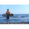 Portrait of a strong young  surf  man at beach on sunset in a contemplative mood with a surfboard