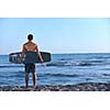 Portrait of a strong young  surf  man at beach on sunset in a contemplative mood with a surfboard