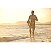 Portrait of a strong young  surf  man at beach on sunset in a contemplative mood with a surfboard