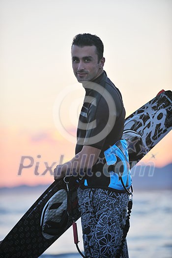 Portrait of a strong young surf man at beach on sunset in a contemplative mood with a surfboard Portrait of a strong young surf man at beach on sunset in a contemplative mood with a surfboard