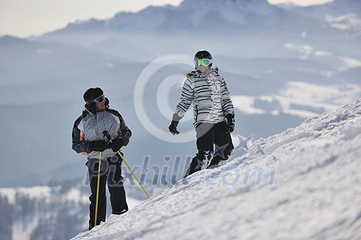 happy couple drivingand relaxing with snowboard and ski at winter seasson on mountain