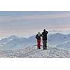 happy young snowboarder couple relax at top of mountain at beautiful sunny winter day