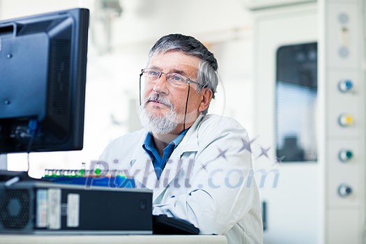 Senior researcher using a computer in the lab while working on an experiment (color toned image)