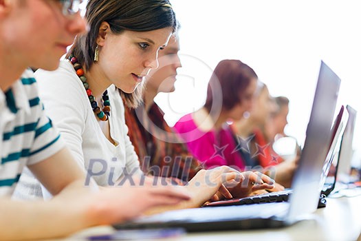 College students sitting in a classroom, using laptop computers during class (shallow DOF)