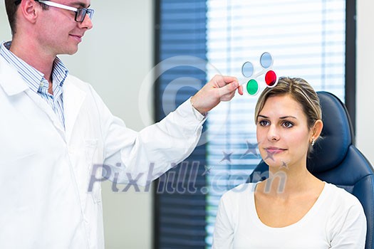 Optometry concept - pretty young woman having her eyes examined by an eye doctor/optometrist (color toned image; shallow DOF) Optometry concept - pretty young woman having her eyes examined by an eye doctor/optometrist (color toned image; shallow DOF)