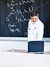 Senior chemistry professor writing on the board while having a chalk and blackboard lecture (shallow DOF; color toned image)