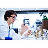 Young male researcher carrying out scientific research in a lab (shallow DOF; color toned image)