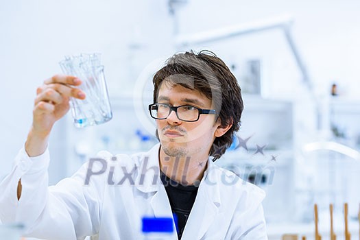 Young male researcher carrying out scientific research in a lab (shallow DOF; color toned image) Young male researcher carrying out scientific research in a lab (shallow DOF; color toned image)