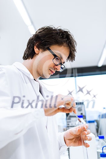 Young male researcher carrying out scientific research in a lab (shallow DOF; color toned image) Young male researcher carrying out scientific research in a lab (shallow DOF; color toned image)