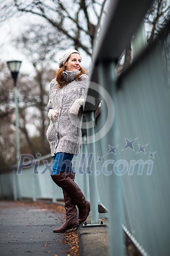 Autumn/winter portrait: young woman dressed in a warm woolen cardigan posing outside in a city park Autumn/winter portrait: young woman dressed in a warm woolen cardigan posing outside in a city park