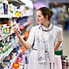 Beautiful young woman shopping for diary products at a grocery store/supermarket (color toned image)