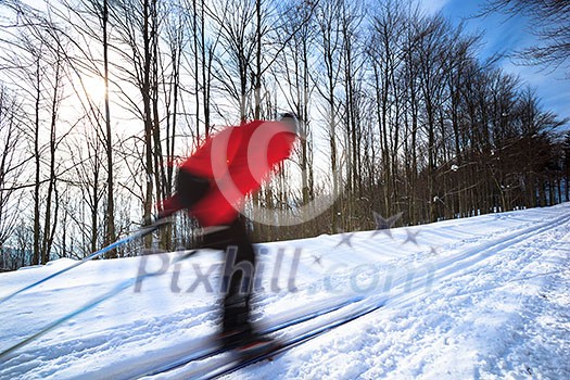 Cross-country skiing: young man cross-country skiing on a lovely sunny winter day