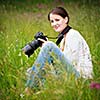 pretty young woman with a DSLR camera outdoors, taking pictures