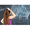 pretty young college student writing on the chalkboard/blackboard during a math class (color toned image; shallow DOF)