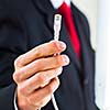 Young businessman holding an ethernet cable - stressing the importance of fast and reliable internet connection for a business (color toned image; shallow DOF)