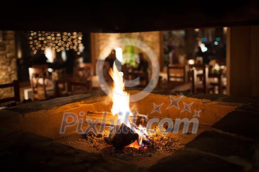 Cosy fireplace in a mountain chalet's warm, wooden interior