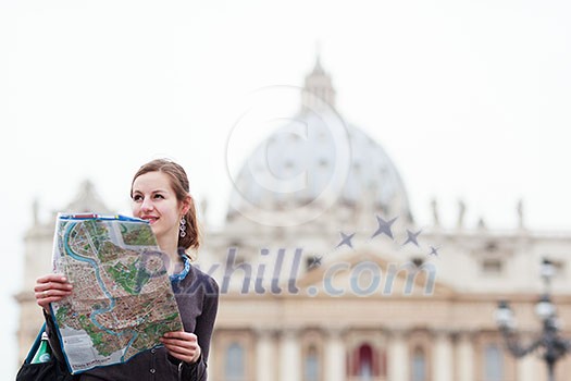 Pretty young female tourist studying a map at St. Peter's square in the Vatican City in Rome