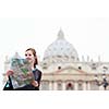 Pretty young female tourist studying a map at St. Peter's square in the Vatican City in Rome