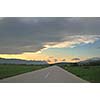 landscape in nature and countryroad adventure with beautiful sunset and dramatic clouds and sky