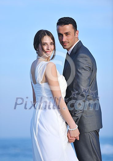 happy just married young couple celebrating and have fun at beautiful beach sunset