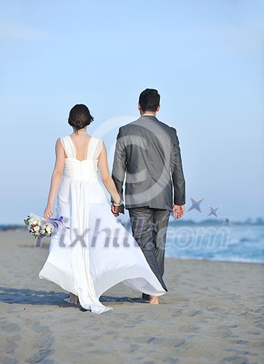 happy just married young couple celebrating and have fun at beautiful beach sunset