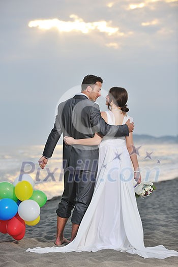 happy just married young couple celebrating and have fun at beautiful beach sunset