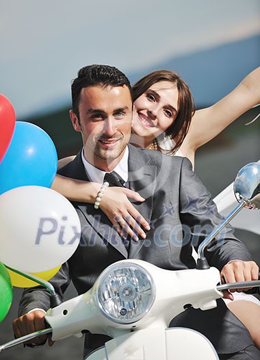 wedding sce of bride and groom just married couple on the beach ride white scooter and have fun