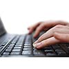 Isolated female hand typing on laptop keyboard