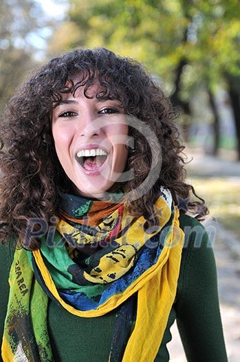 brunette Cute young woman with colorful scarf smiling outdoors in nature
