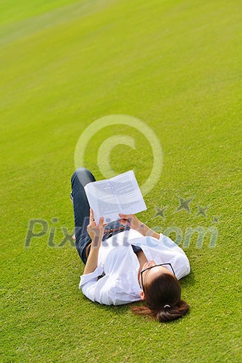 Young student woman reading a book and study in the park