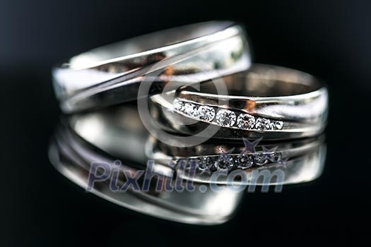 Wedding day details - two lovely golden wedding rings awaiting their moment, with some nice reflections Wedding day details - two lovely golden wedding rings awaiting their moment, with some nice reflections