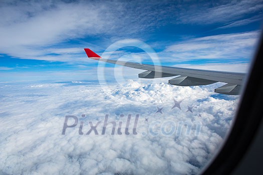 Spectacular view from  an airplane's window, offering a view of lovely clouds and blue sky while traveling fast