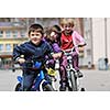 happy childrens group learning to drive bicycle outdoor at beautiful sunny spring day