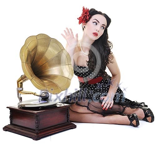 pretty girl listening music on old gramophone isolated on white in studio